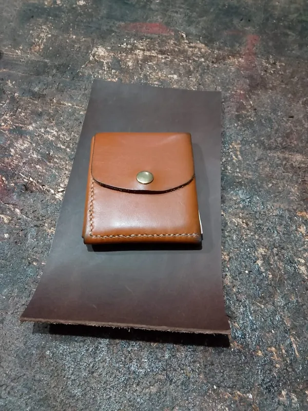 Portefeuille en cuir cognac à pression, sur l'établi